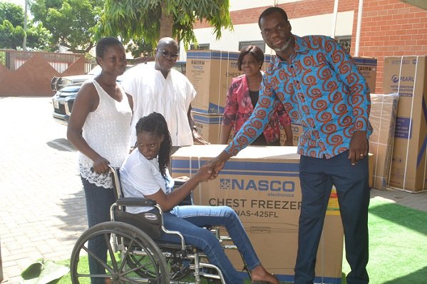 Mr Anyetei presenting an item to one of the beneficiaries. With them is Ms Mensah (second from right) Photo Victor A. Buxton