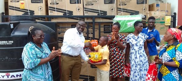 • Alhaji Fuseini (second left) presenting some items to a beneficiary.