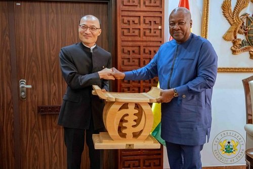 President Mahama presenting a gift to Mr Tong Defa,the outgoing Chinese Ambassador to Ghana