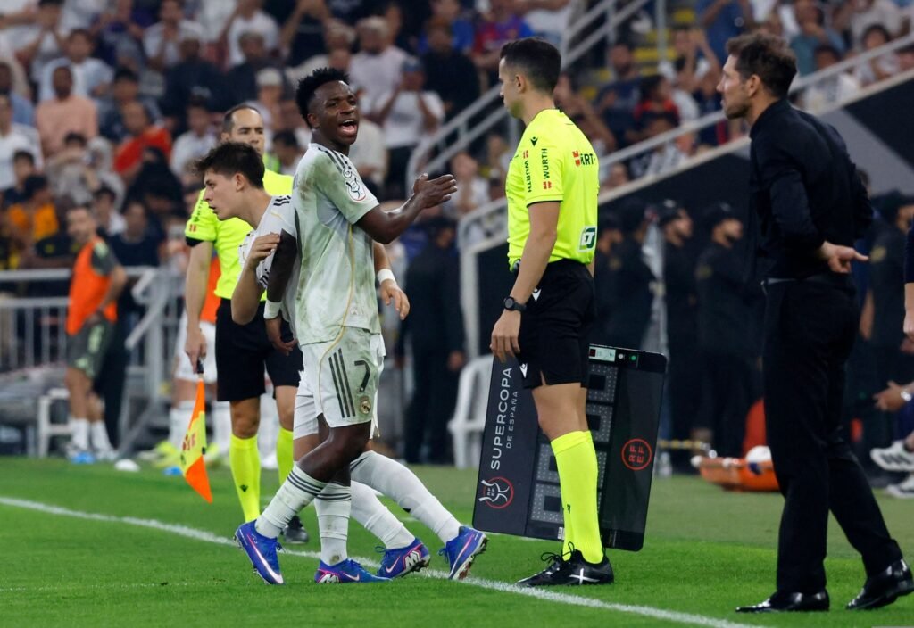 Vinicius (left) takes a swipe at Simeone after heated tussle