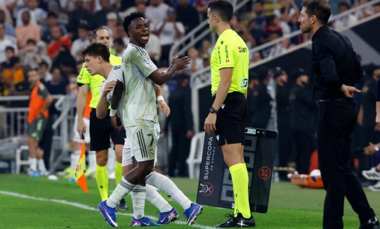 Vinicius (left) takes a swipe at Simeone after heated tussle