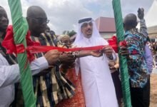 Mr Abdul-Latif Dan (in smock) being assisted to cut the tape to inaugurate the facility