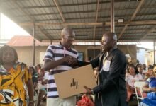 • Dr Michael Mensah (right) presenting an item to a beneficiary