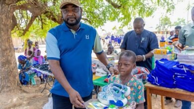 Mr Oluu presenting some items to a beneficiary