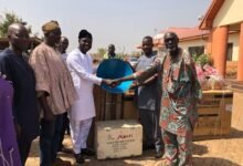 Alhaji Mahama (thid from left) handing over an item to a beneficiary