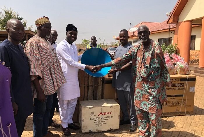 Alhaji Mahama (thid from left) handing over an item to a beneficiary