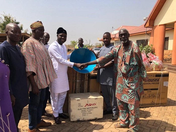 Alhaji Mahama (thid from left) handing over an item to a beneficiary