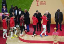 Morocco players are consoled on the stage by CAF president Patrice Motsepe and FIFA president Gianni Infantino as they collect their runners up medals after the finals