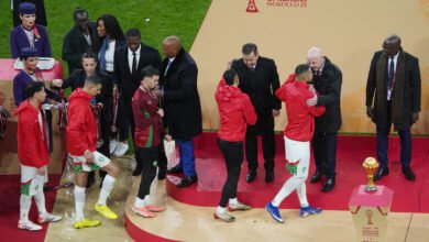 Morocco players are consoled on the stage by CAF president Patrice Motsepe and FIFA president Gianni Infantino as they collect their runners up medals after the finals
