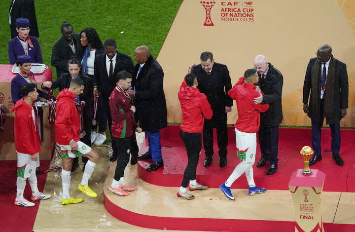 Morocco players are consoled on the stage by CAF president Patrice Motsepe and FIFA president Gianni Infantino as they collect their runners up medals after the finals