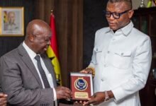 Mr Kwabena Yeboah (left) presents a SWAG branded souvenir to Mr Adams