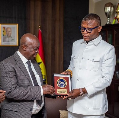 Mr Kwabena Yeboah (left) presents a SWAG branded souvenir to Mr Adams