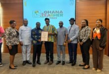 Dr Apaak (in smock) presenting a certificate of honour to one of the sponsor