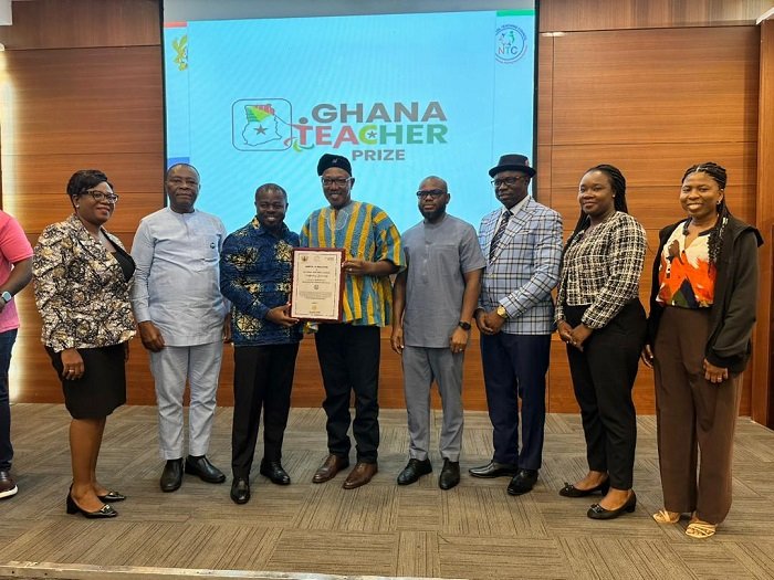 Dr Apaak (in smock) presenting a certificate of honour to one of the sponsor