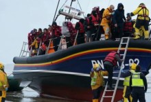 • Immigration ofcers helping migrants to disembark from a small boat