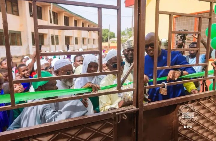 : Alhaji Tikumah being assisted by other dignitar ies to cut the tape to formally open the facility