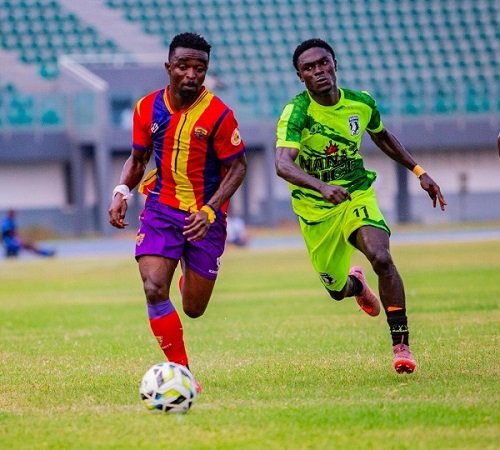 • Heart's Martin Karikari in a tussle for the ball with Emmanuel Abban (in green)