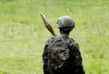 A Rwanda Defence Force (RDF) soldier stands in position at the Grande Barrier border