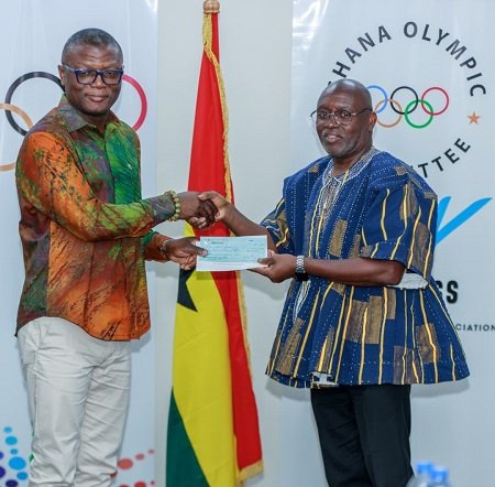 Mr Kofi Adams (left) receives a cheque from the GOC President, Richard Akpokavie