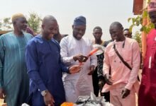 Alhaji Mahama (middle) presenting one of the equipment to a beneficiary