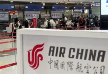 People line up in front of an Air China’s counter at Beijing Capital International Airport in Beijing yesterday for the direct flight