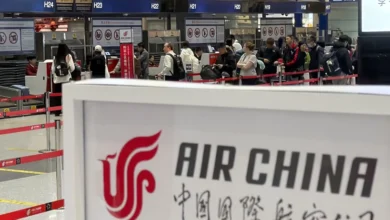 People line up in front of an Air China’s counter at Beijing Capital International Airport in Beijing yesterday for the direct flight