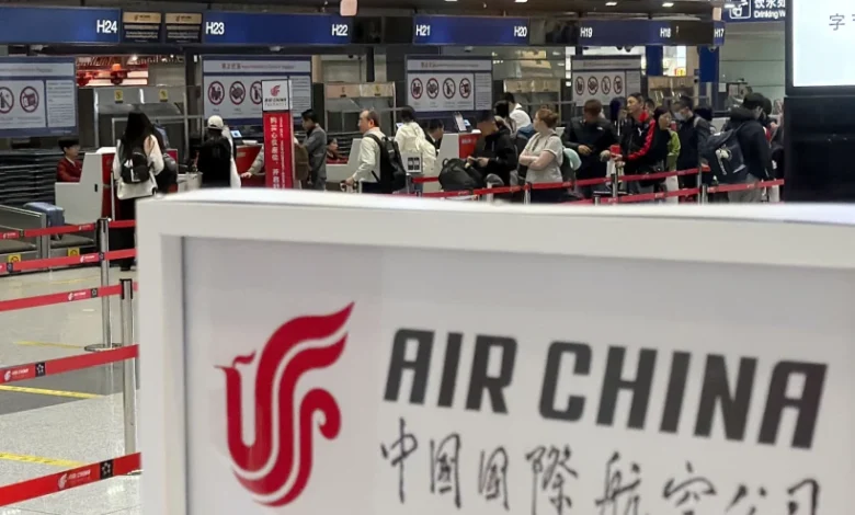People line up in front of an Air China’s counter at Beijing Capital International Airport in Beijing yesterday for the direct flight