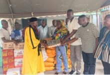 Alhaji Leetei Mensah (left) receiving some of the items from Mr Anyetei (third from right) and Ms Sowah (second from left)