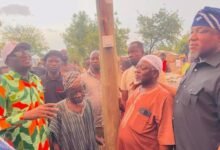 Alhaji A. Mumuni (left, in cap) about to switch on the light during the inauguration
