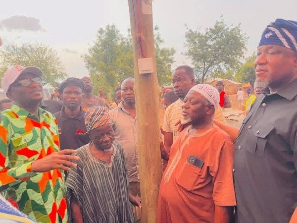 Alhaji A. Mumuni (left, in cap) about to switch on the light during the inauguration