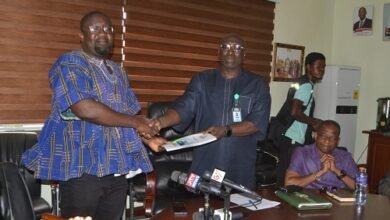 Mr Amaliba (second from left) receiving the report from Mr Ayetor at the programme Photo Victor A. Buxton