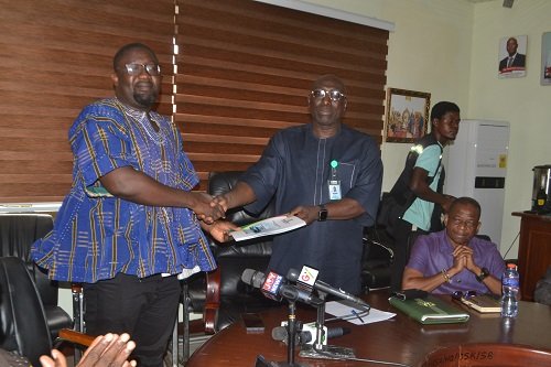 Mr Amaliba (second from left) receiving the report from Mr Ayetor at the programme Photo Victor A. Buxton