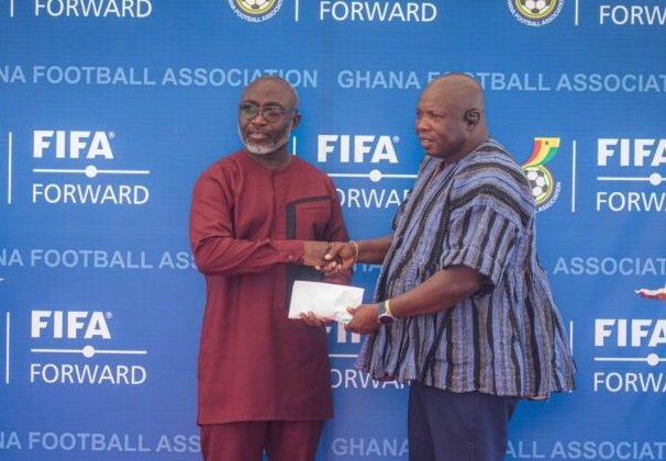 Chairman of the Greater Accra RFA Mr Samuel Aboabire (right) receives documents to the vehicle from the General Secretary of the GFA Mr Prosper Harrison Addo