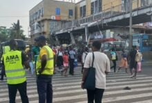 AMA taskforce aiding some pedestrians crossing the road at Kaneshie