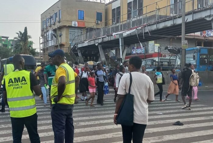 AMA taskforce aiding some pedestrians crossing the road at Kaneshie