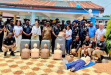 Mr Yohuno ( standing, sixth from right ) receiving the donated items