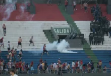 Fans of Cerro Porteno clash with police officers during their team’s match against Olimpia at the Defensores del Chaco stadium in Asuncion