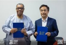 Mr Goosie Tanoh (left) and Mr He Liu showing the signed document