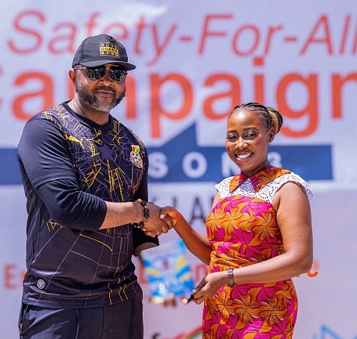 Madam Humphey presenting the first copy of her book to Mr Ampofo Ankrah