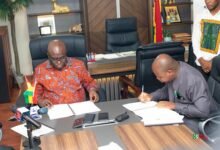 Mr Opoku (left) and Mr Amevor signing the MoU