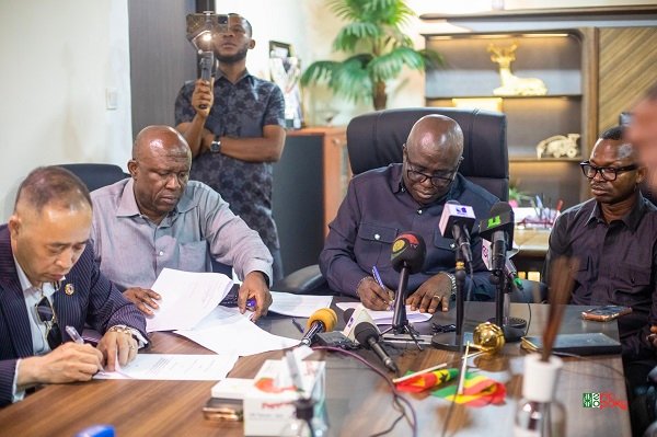 Mr Eric Opoku (second from right) and Mr. Ningquan Xu signing the MoU