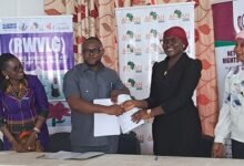 Mr Tei-Nobi (second from left) shaking hands with Ms Janat Issifu after signing the contract. With them is Ms Asare (left)