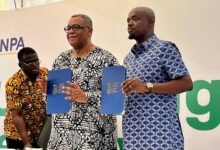 Mr Tameklo (right) and Mr Goosie Tanoh showing the signed doocument at the programme