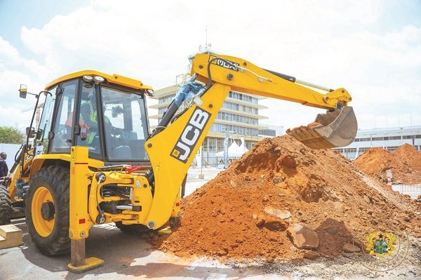 President Mahama being assisted to operate the excavator machine to cut the sod for the project