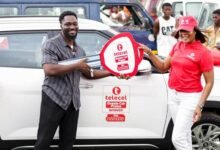 Mr Ofori-Ennin (left) receiving the key to his car from a Telecel Ghana official