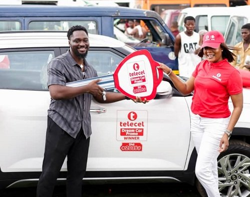 Mr Ofori-Ennin (left) receiving the key to his car from a Telecel Ghana official