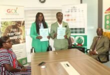 Ms Abekah (standing left) and Mr Darko showing the signed MoU Photo. Ebo Gorman