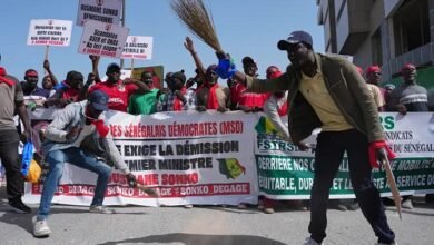 Workers hold placards and banners as they assemble to march, demanding that the government honours it committments and address their concerns