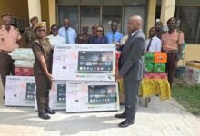 -Mr Brantuo presenting the items to Mrs Ashong-Mettle, while other officers and employees of the bank look on.