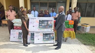 -Mr Brantuo presenting the items to Mrs Ashong-Mettle, while other officers and employees of the bank look on.
